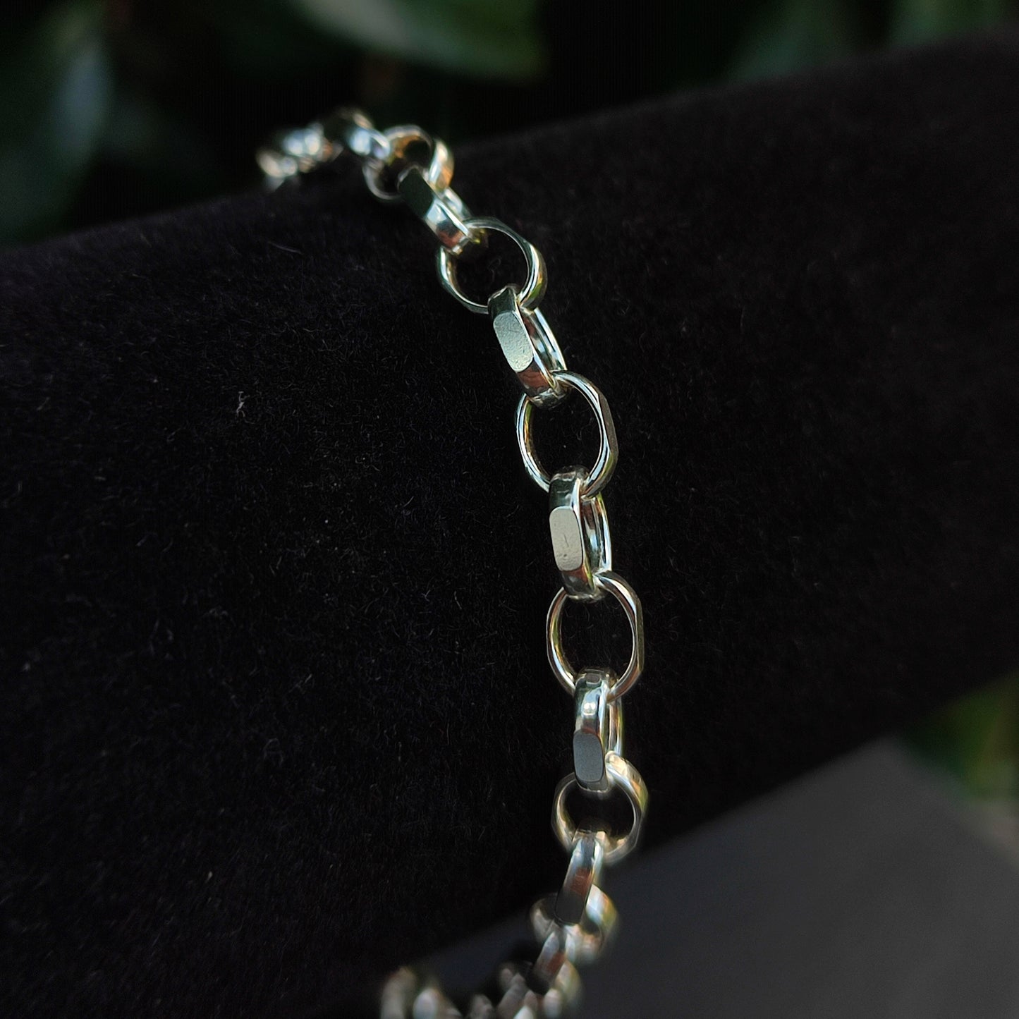 A close-up of the Belcher Chain Bracelet- Sterling Silver by silverhollowjewellery, featuring diamond cut belcher links, displayed on a black velvet holder.