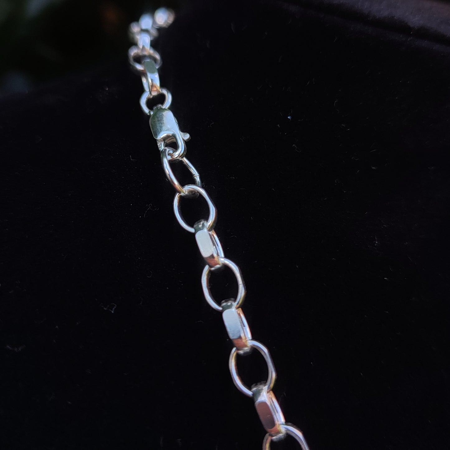 A close-up of the Heavy Belcher Chain Necklace by silverhollowjewellery, crafted in sterling silver with oval links and a diamond cut finish, shown against a black background.