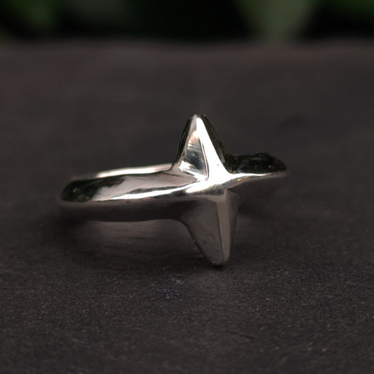 The North Star Ring Sterling Silver by silverhollowjewellery features a raised, abstract cross-inspired design on dark silver; its unisex style suits any look.
