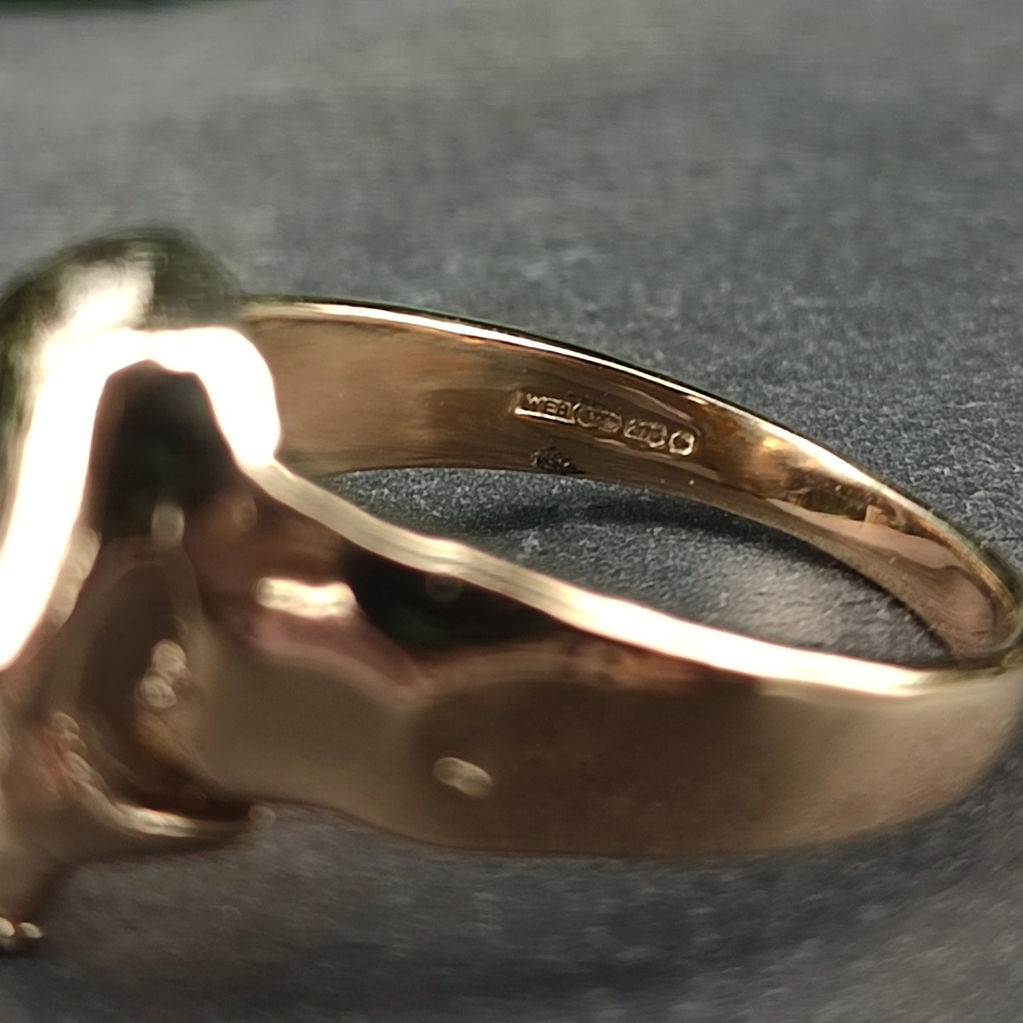 Close-up of the silverhollowjewellery Skull Ring 9ct Gold, featuring engraved hallmarks and numbers on the inner band.