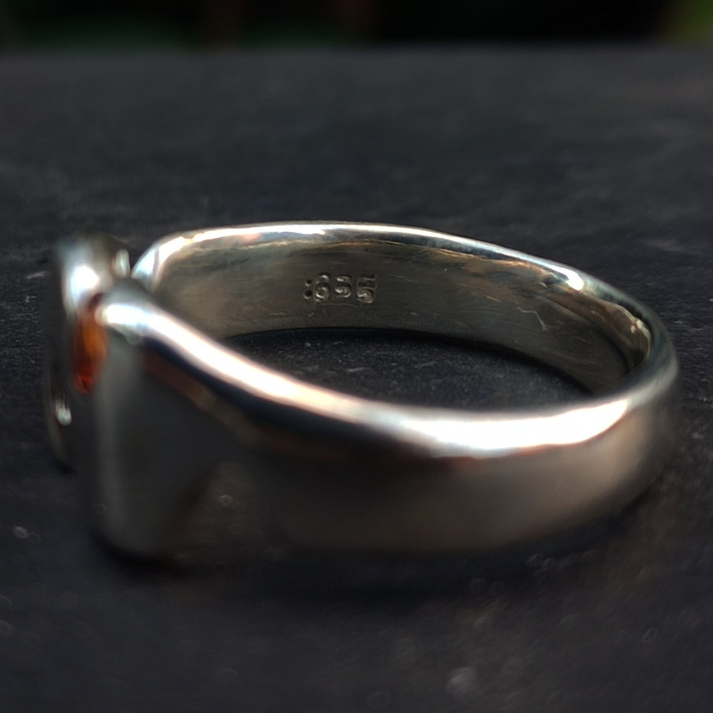 A close-up of the Sand Cast Sapphire Ring by silverhollowjewellery, crafted from recycled sterling silver, featuring a ".925" stamp on the inner band to indicate quality.