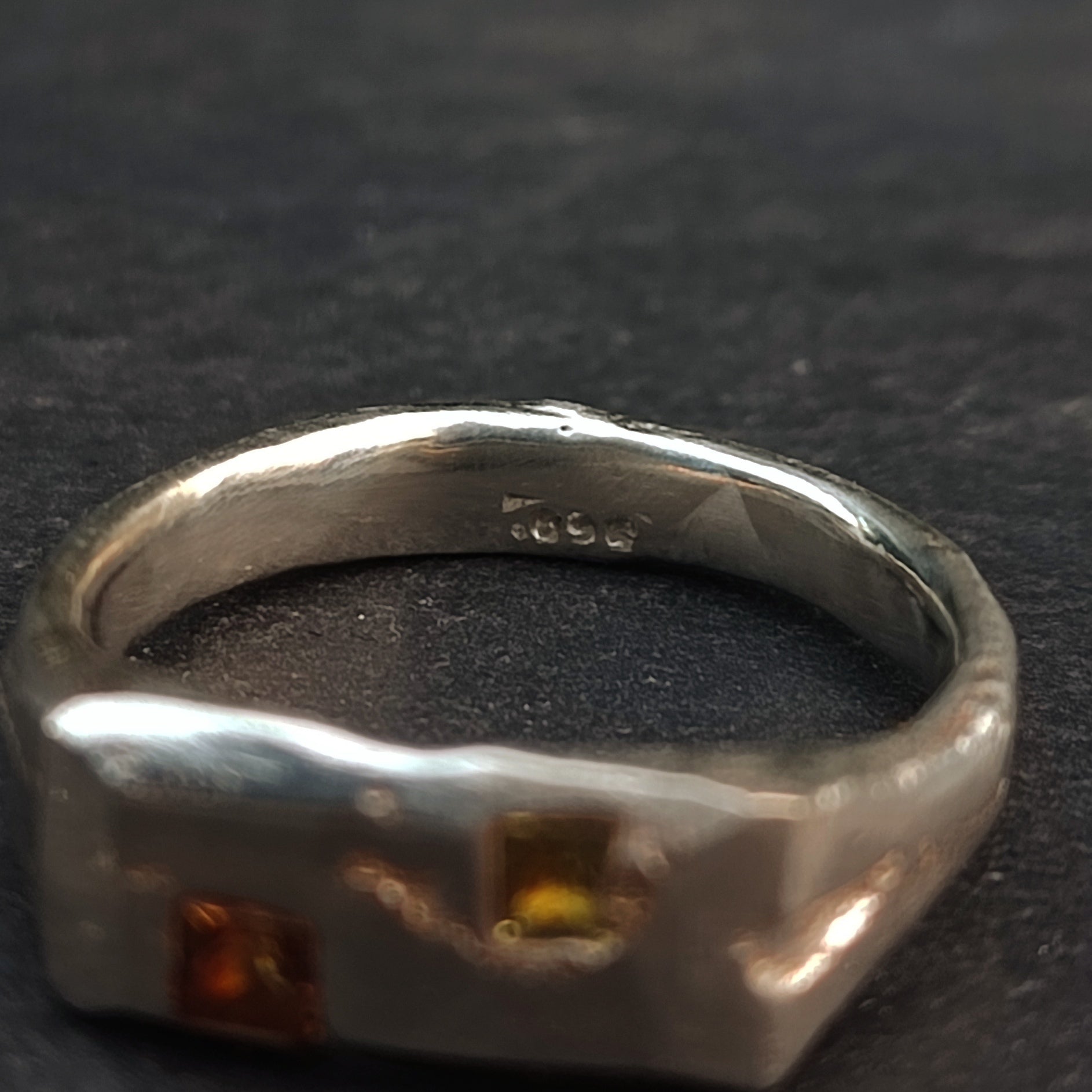 Close-up of the Sand Cast Sapphire Ring by silverhollowjewellery, made from recycled sterling silver with "299" engraved inside and two square princess cut sapphires on the outer band.