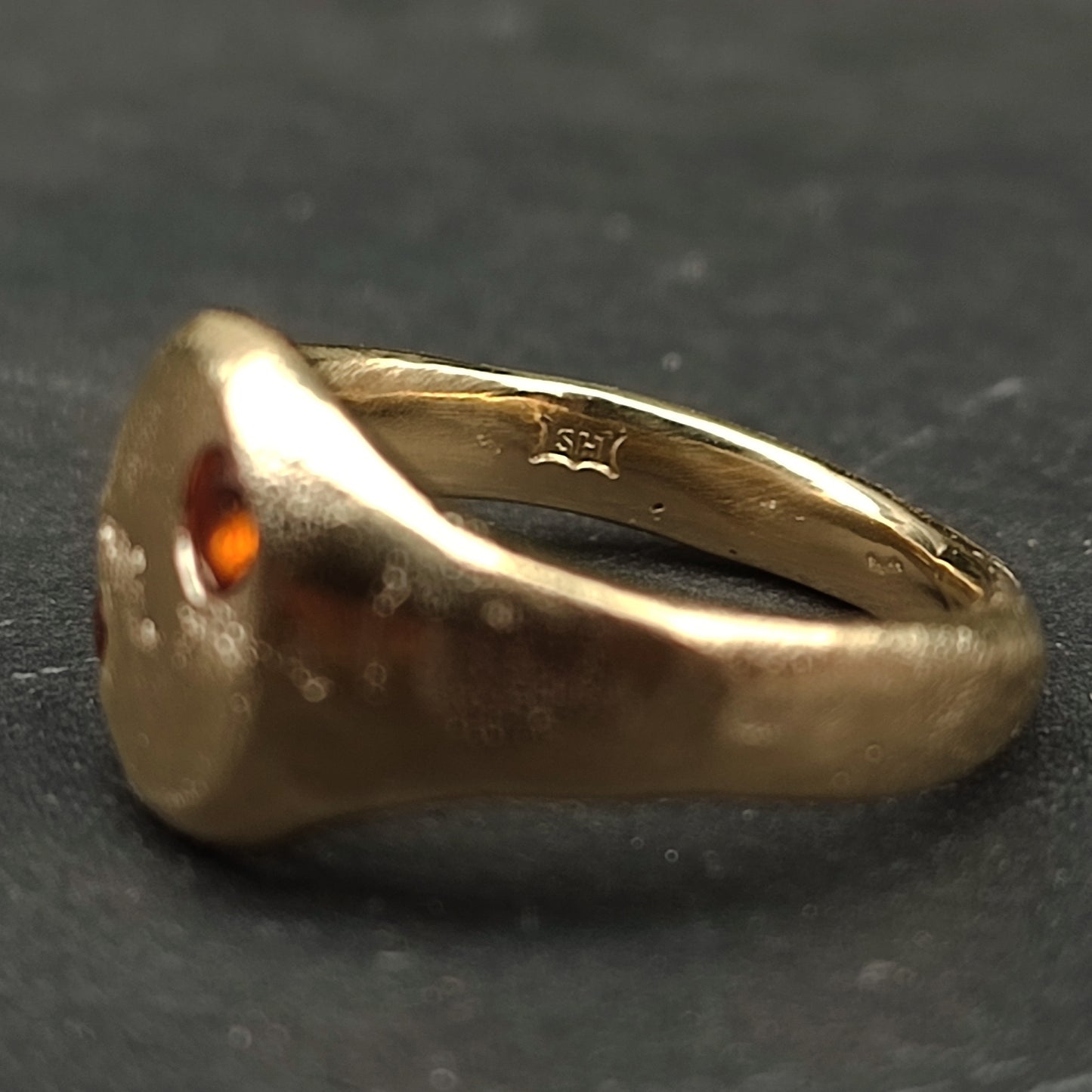 The 9ct Sandcast Sapphire Signet by silverhollowjewellery is a gold ring with a sapphire, shown from the side, featuring an inner band hallmark and crafted using traditional sand casting.
