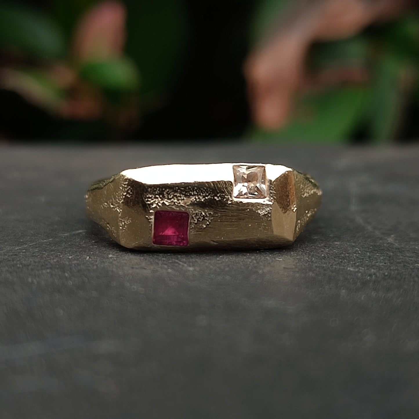 The 9ct Sandcast Sapphire/Ruby Signet by silverhollowjewellery features a rough, geometric gold design with a square red ruby and square white sapphire set on top, crafted using the sand casting method.