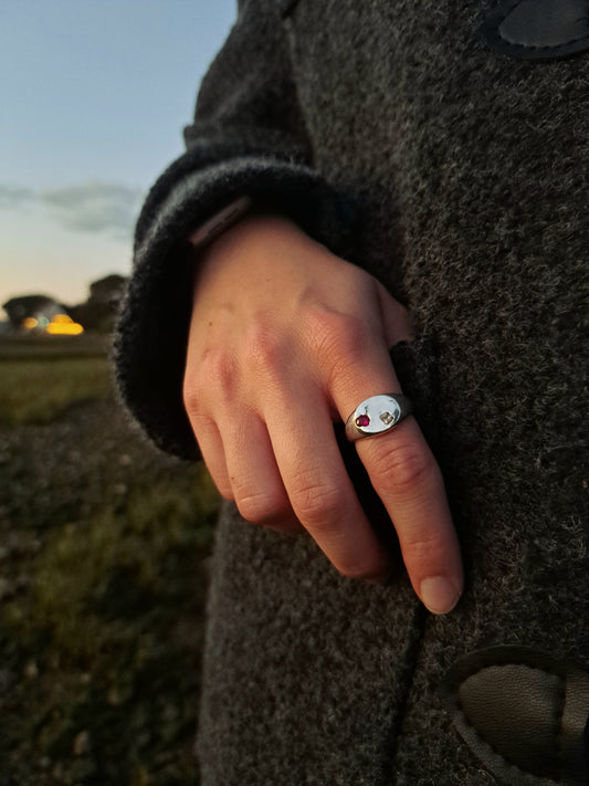 Silver sandcast sapphire minimalist ring being worn with a woven jacket