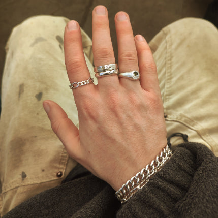 Man wearing different styles of silver rings