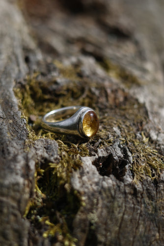 Sterling silver citrine ring displayed on a rock surface