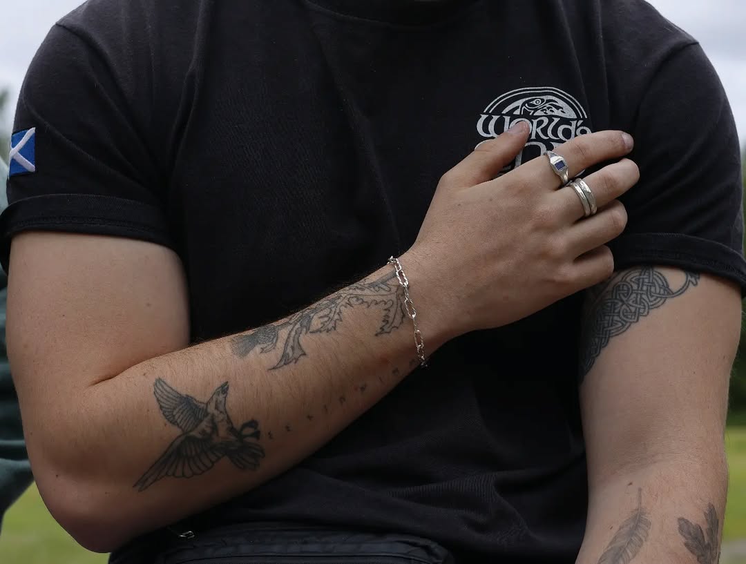A man wearing a sterling silver bracelet and silver rings