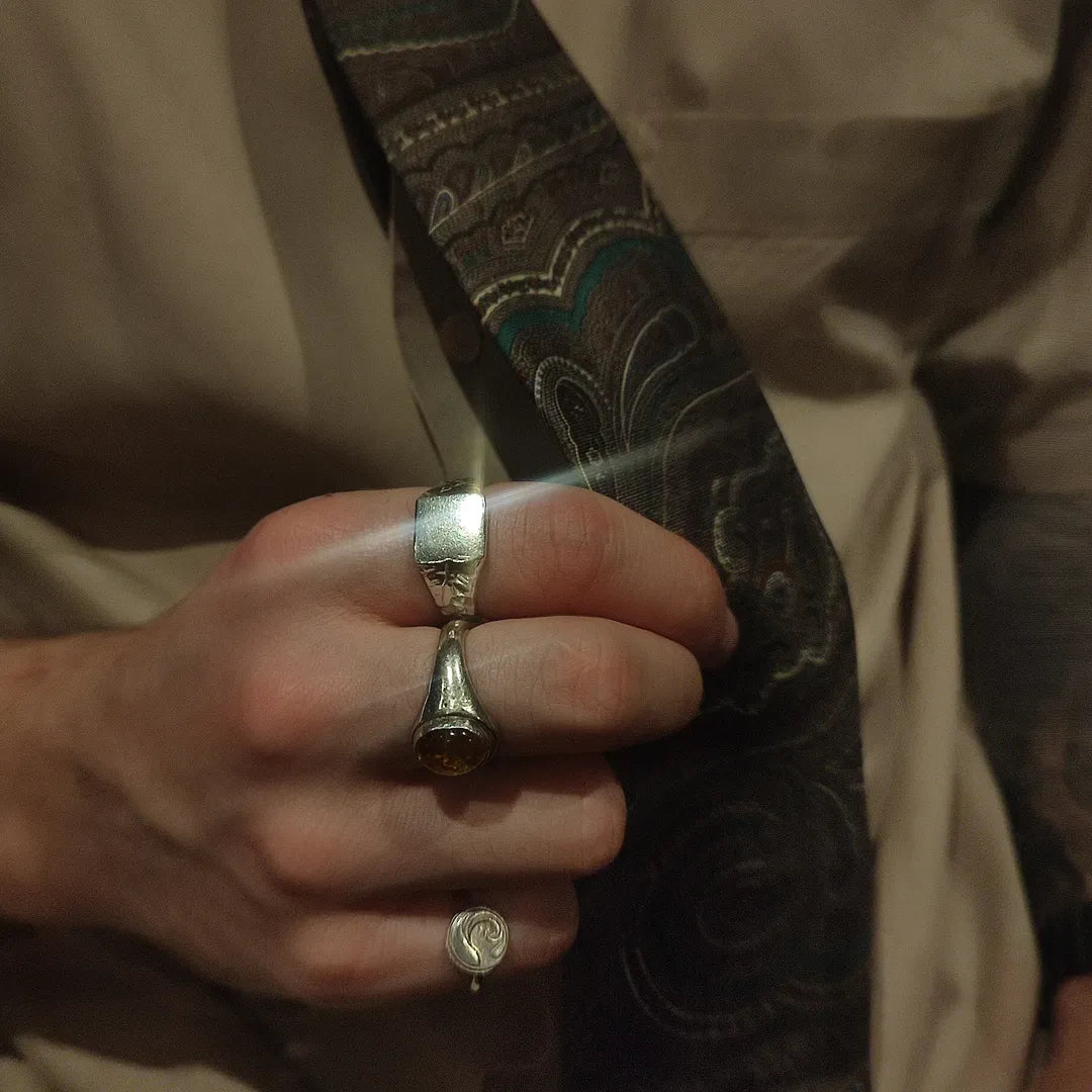 A man wearing nature inspired handmade silver rings