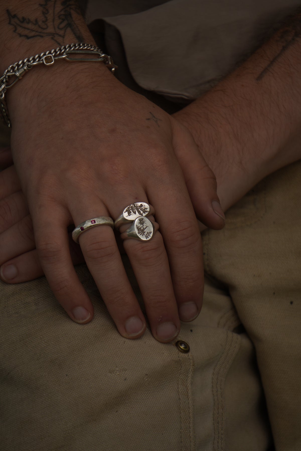 Close-up of hands with rings on a beige fabric background