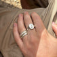 hand wearing silver ring with an engraved sitting hare design