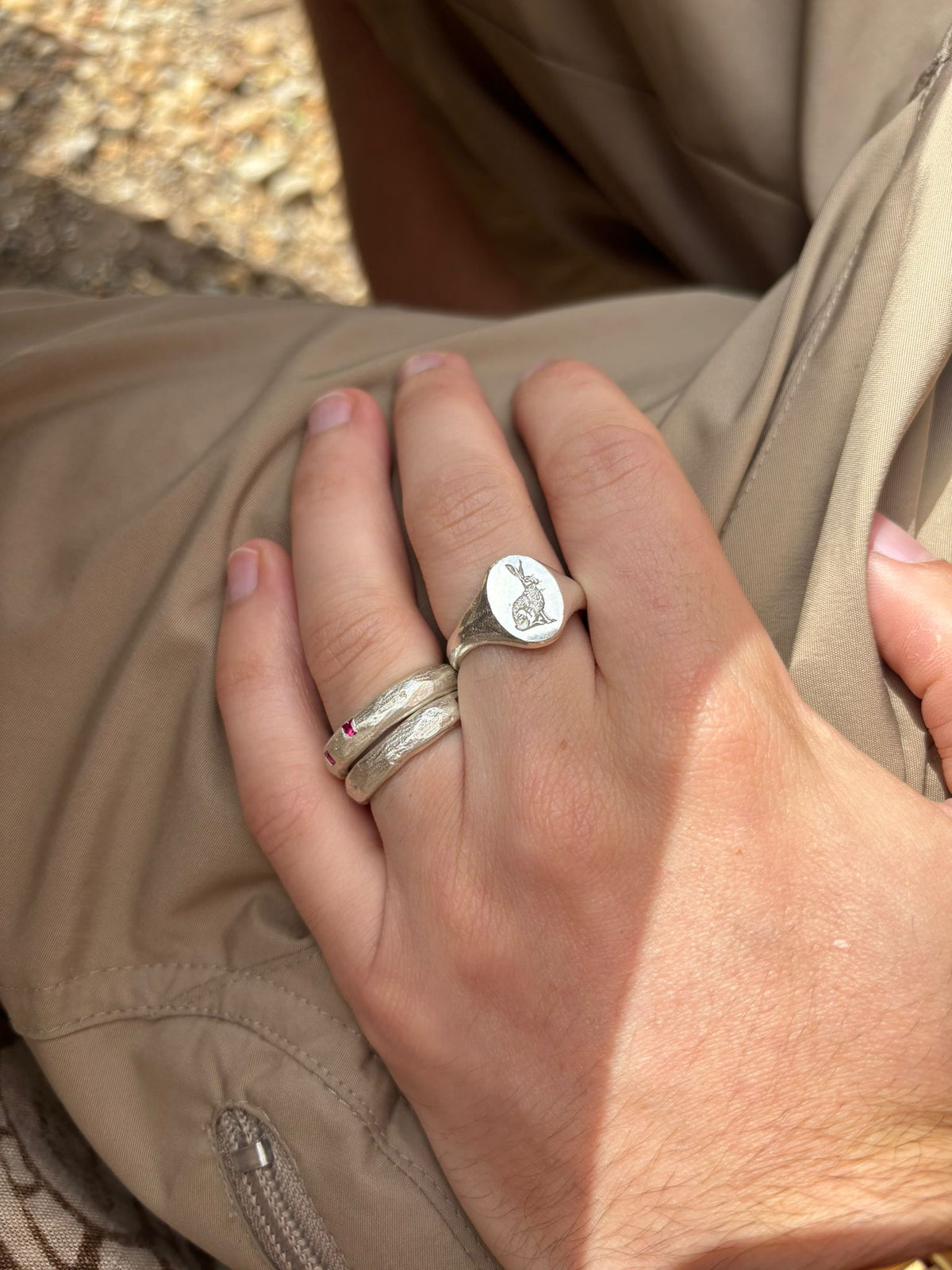hand wearing silver ring with an engraved sitting hare design