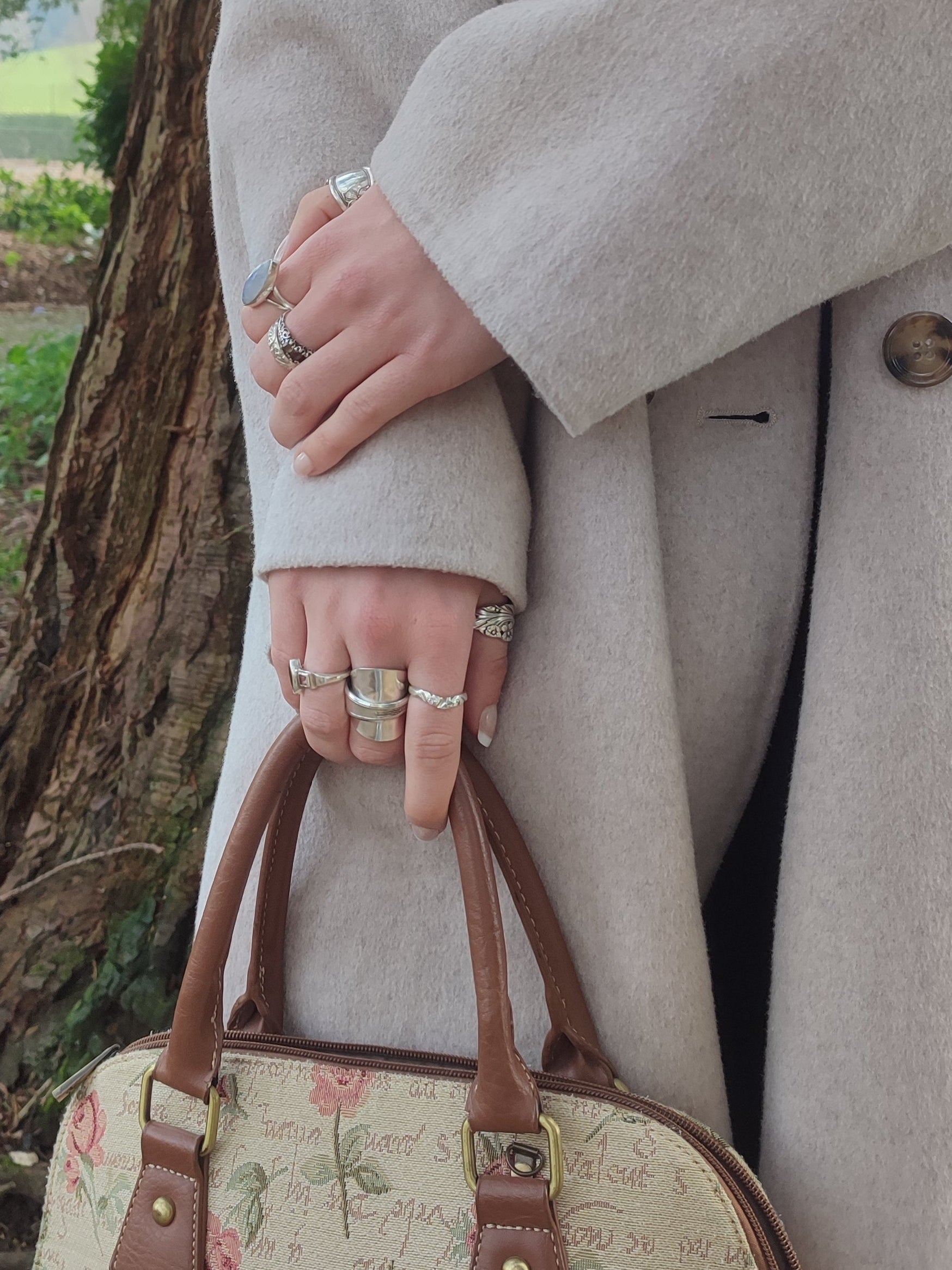 Woman wearing spoon rings holding a handbag 